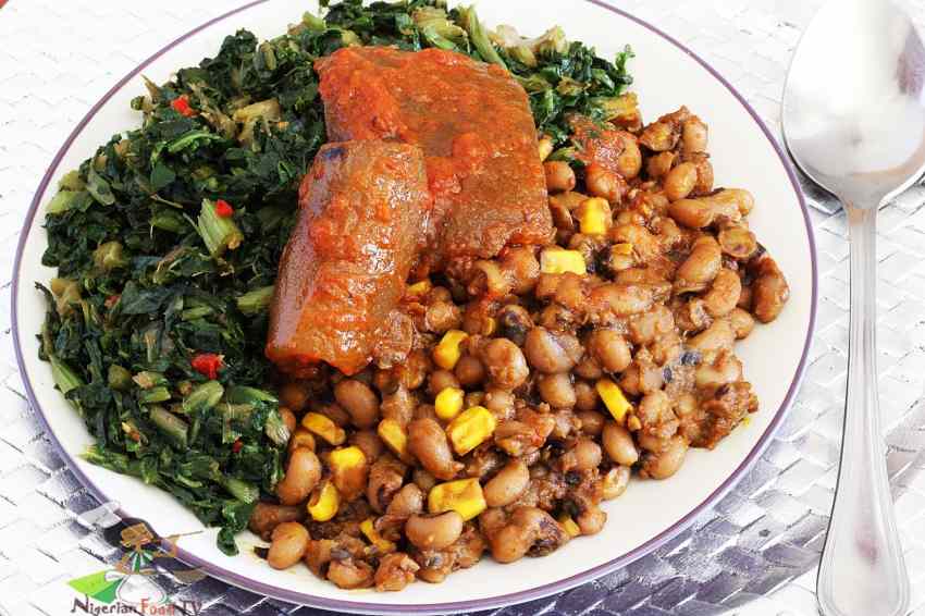 Nigerian beans and corn adalu with steamed vegetables