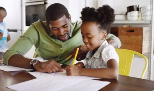 Black father helping child with homework