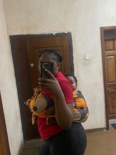 Dawn immanuel and her son strapped to her back